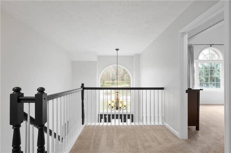 From the second floor, enjoy a stunning view down into the foyer, framed by the elegant Palladium window that fills the space with natural light.