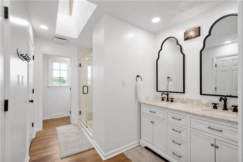 Experience ultimate indulgence in this beautifully updated primary ensuite, featuring a luminous skylight, an elegant double-sink quartz vanity, and a spa-inspired walk-in tiled shower.