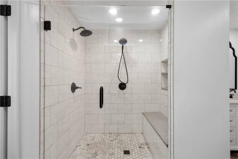 Another standout feature is the stunning tiled shower, complete with dual shower heads and a spacious bench—designed for comfort and indulgence.