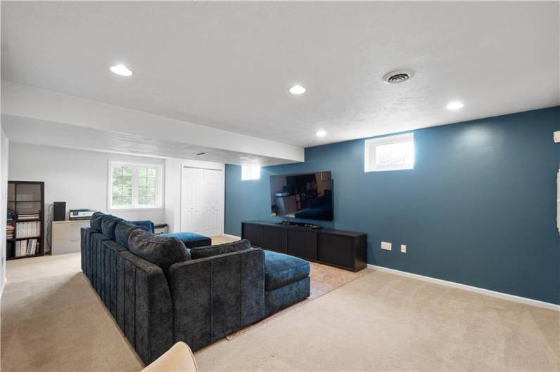 The walk-out game room boasts sleek recessed lighting and a large window that floods the space with natural light—ideal for entertaining, streaming your favorite series, or a versatile playroom for the kids.