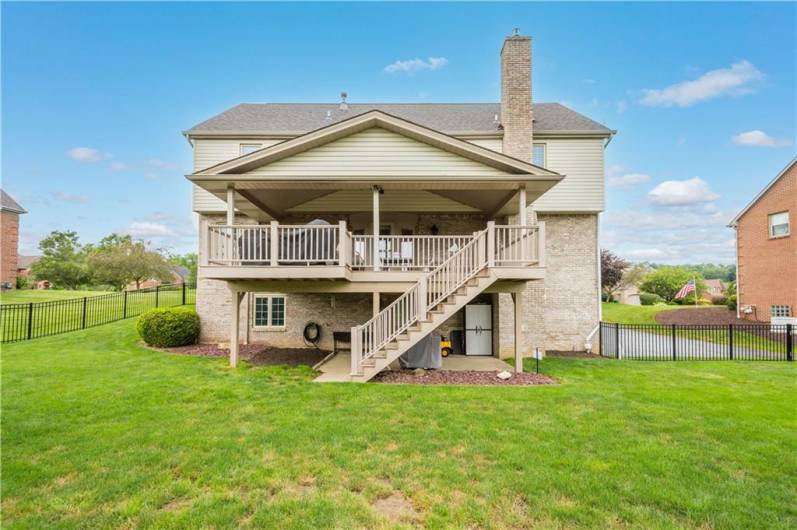 The deck features stairs leading down to a fenced, level backyard—perfect for outdoor living and play.