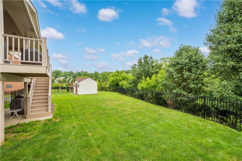 The level, fenced backyard is easily accessible from the deck via stairs—offering a safe and spacious outdoor area.