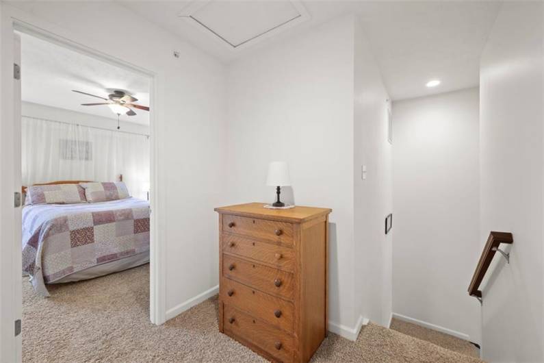 The hallway has a linen closet and has extra space for a dresser or bookcase.