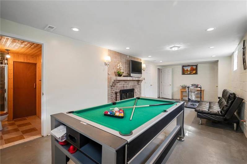 Basement features another wood burning fireplace