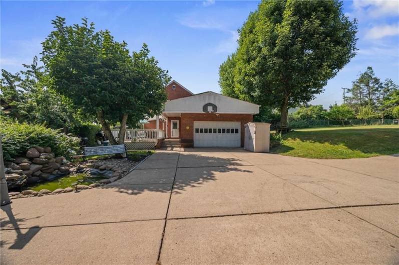 Attached 2 car garage, pond to the left, and a covered deck for entertaining or relaxing