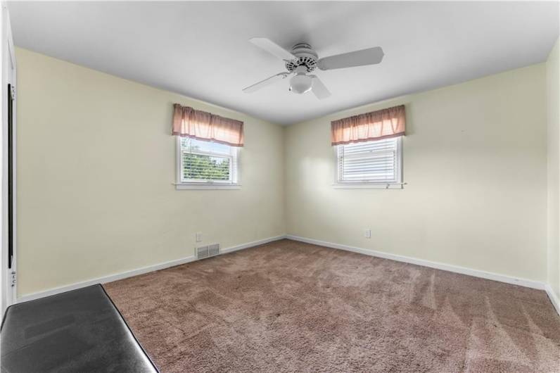 The Primary Bedroom is located on the first floor, featuring wall to wall carpeting, ceiling fan and blinds.