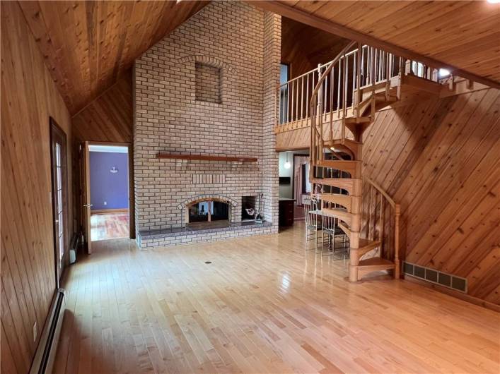 Two story fireplace, a spiral stair case and maple floors