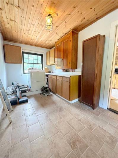 LAUNDRY/PANTRY/MUD ROOM: At 14'x8' this room is exceptionally useful, with ceiling high top cabinets for your Costco storage, four bottom cabinets for your cleaning supplies, and natural pine ceiling. The ceramic tile floor is another big plus for when folks are coming in from the back yard!