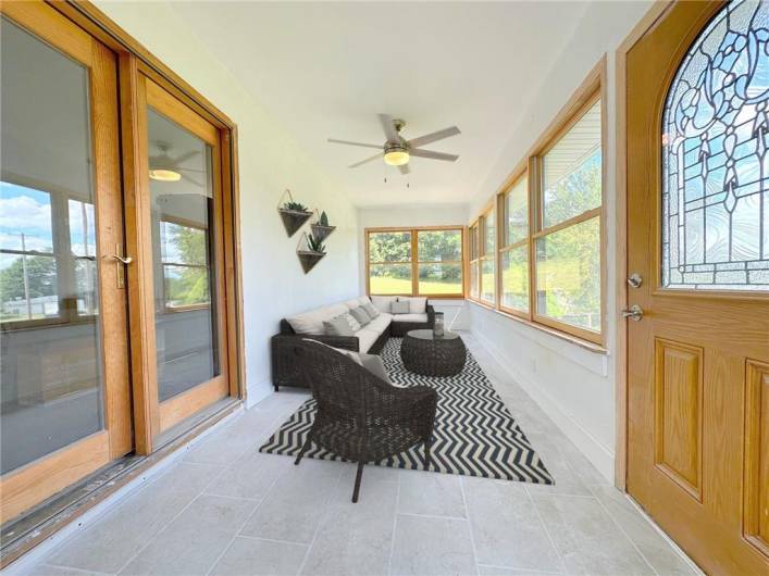 VIRTUALLY STAGED: The Seller just invested several thousand dollars to have professionally installed a top of the line wall HVAC unit  to make this a four-season front room with so many uses; here it is staged as a comfy front Patio with a scenic  southern country view.