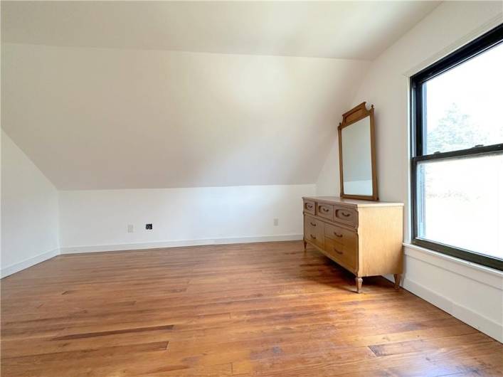 BEDROOM #3 UPPER LEVEL:This photo is the 14'x13' bedroom without the virtual staging; the beautiful original solid oak flooring was recently refinished.